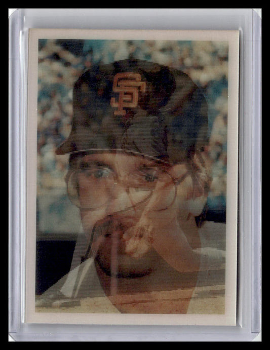 Vintage baseball card of a player wearing a cap with a logo, held against a blurred background.